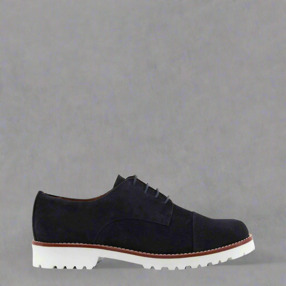 Black suede shoe with white sole on a white background