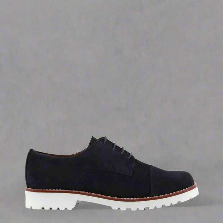 Black suede shoe with white sole on a white background
