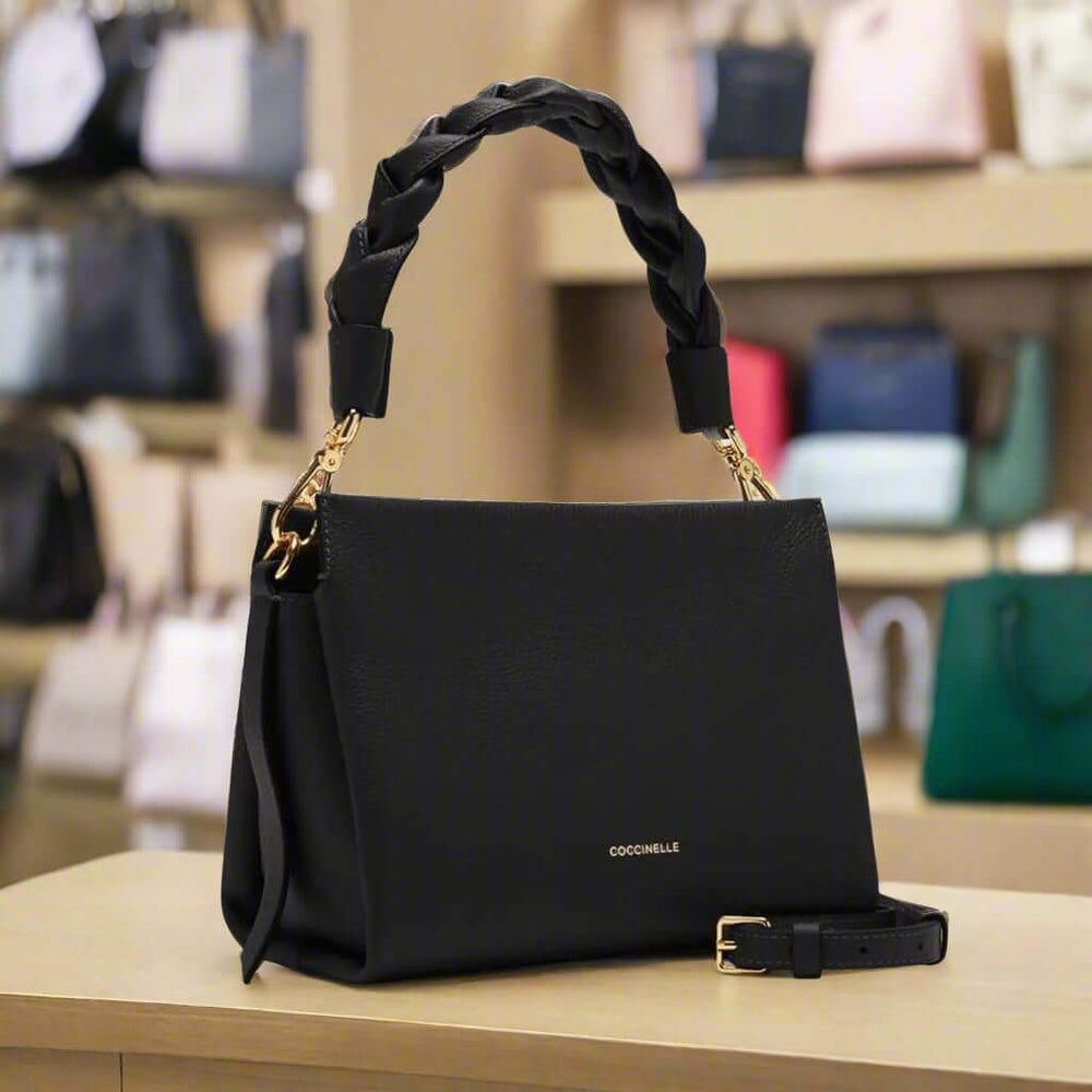 Black handbag with braided handle on a white background