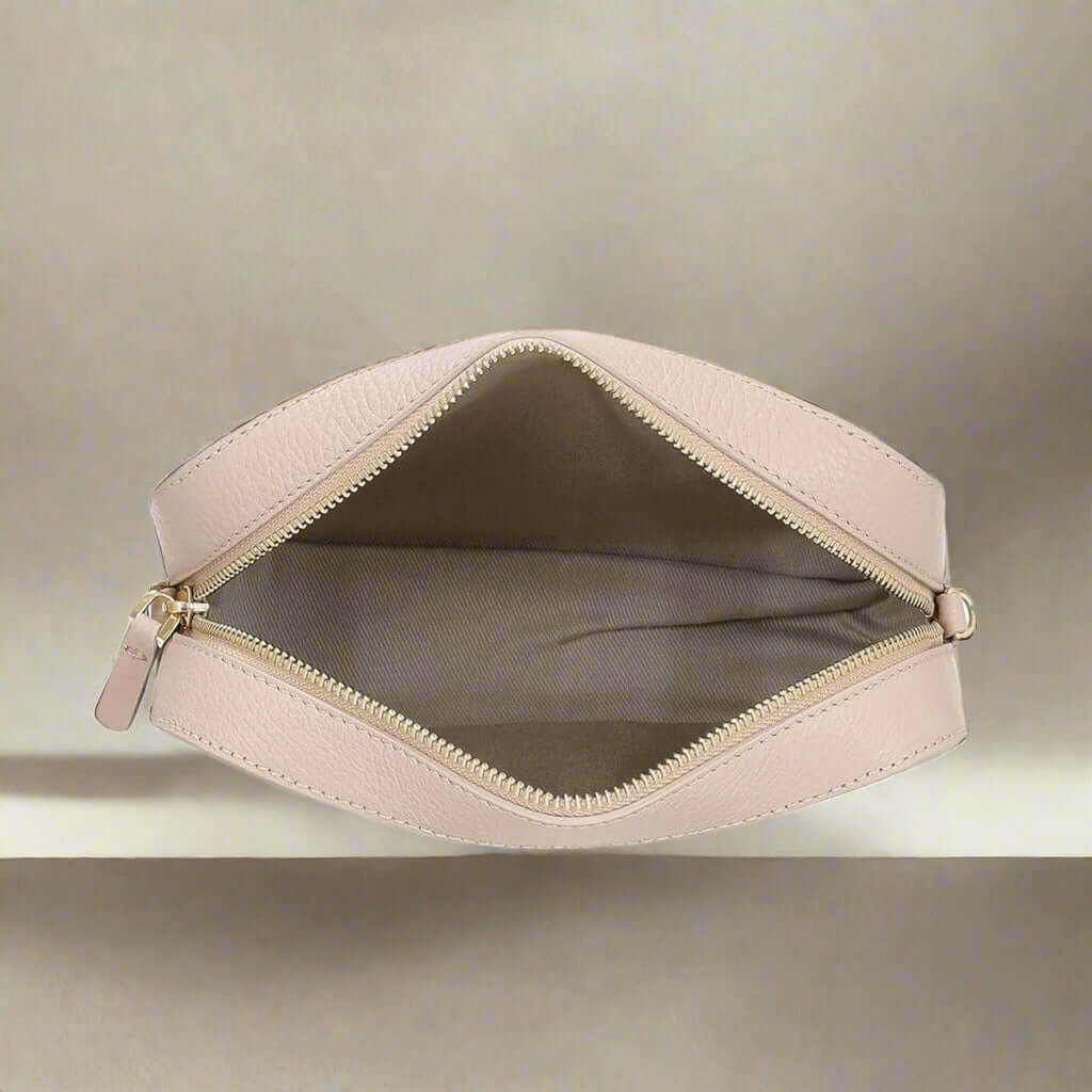 Beige makeup bag with gold zipper on a white background
