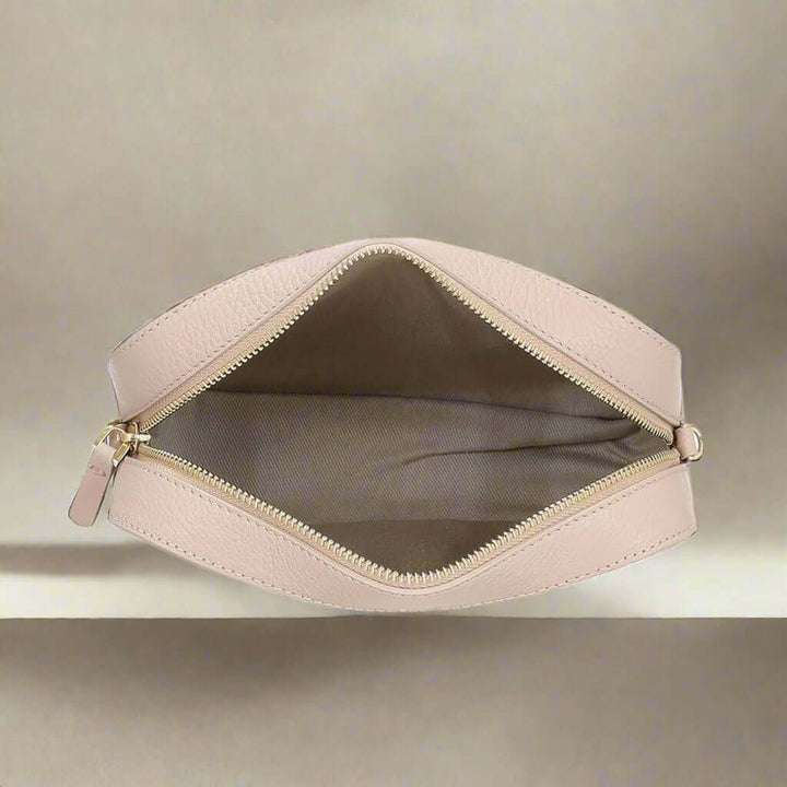 Beige makeup bag with gold zipper on a white background
