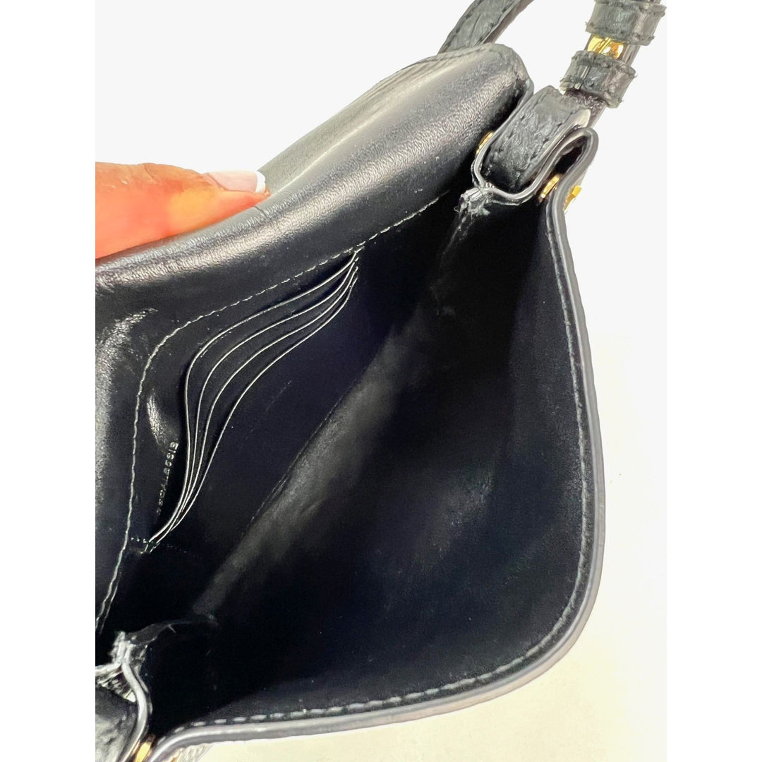 Close-up of a black leather handbag with visible stitching on a white background