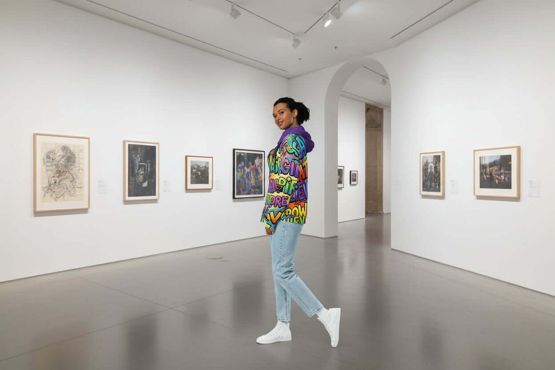 Model showcasing S7 Multicolor Inspiration Hoodie – Purple Edition in an art gallery, blending luxury fashion with creativity.