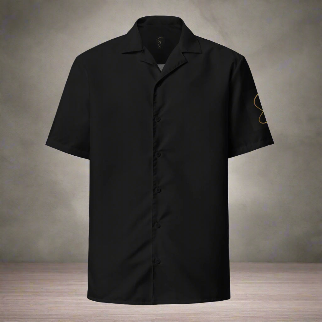 A black unisex button shirt with short sleeves, featuring a small round neckline and a front pouch. The shirt is designed with a graphic of salsa dancers on the front.