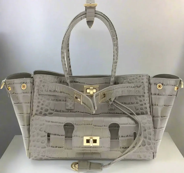 Gray textured handbag with gold accents on a white background