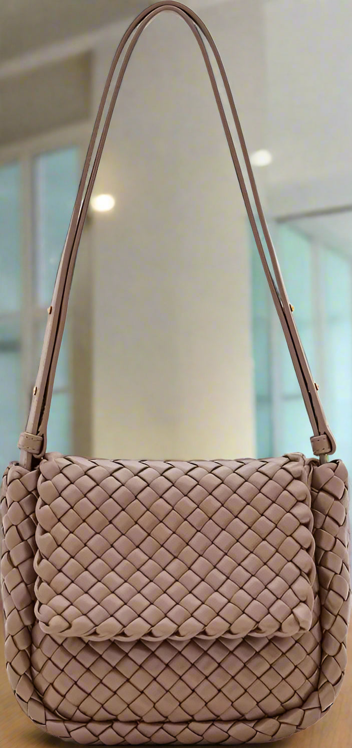 Beige woven handbag with a shoulder strap on a white background