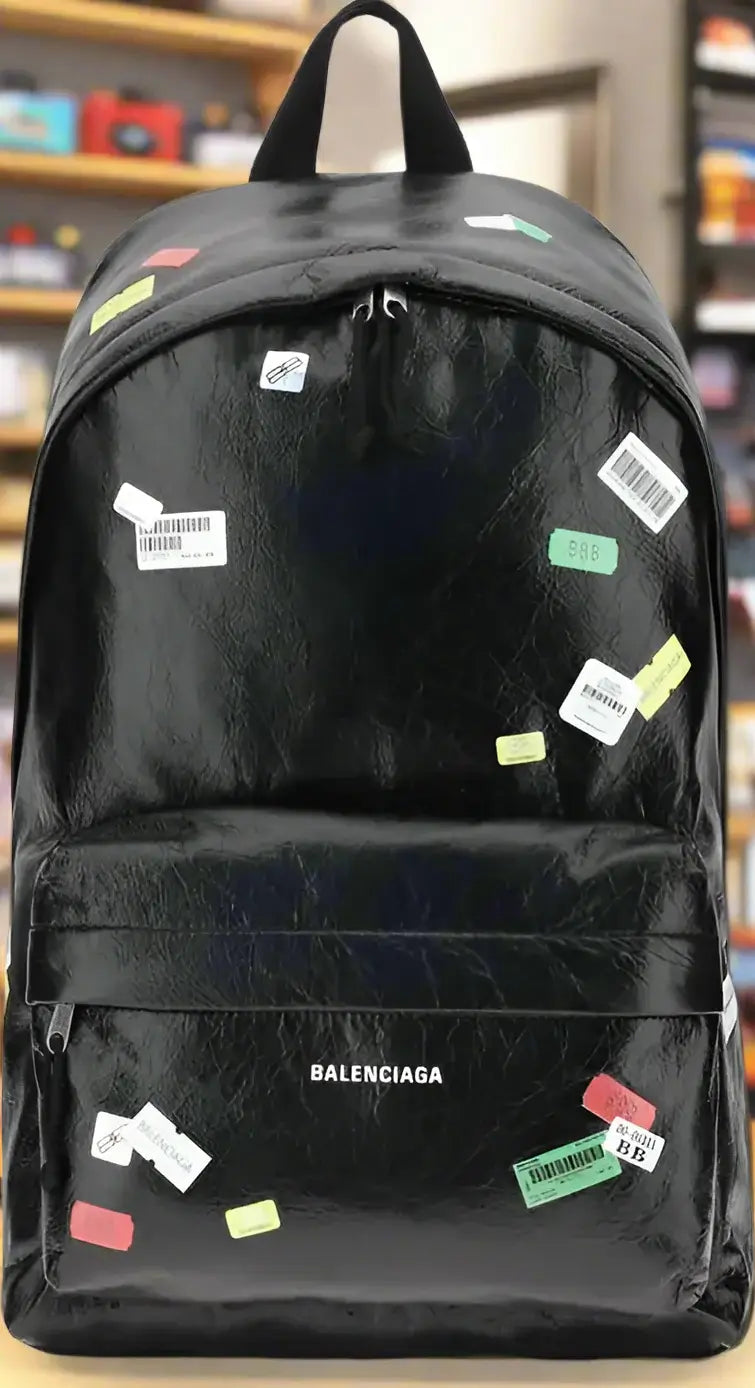 Black backpack with colorful stickers on a white background