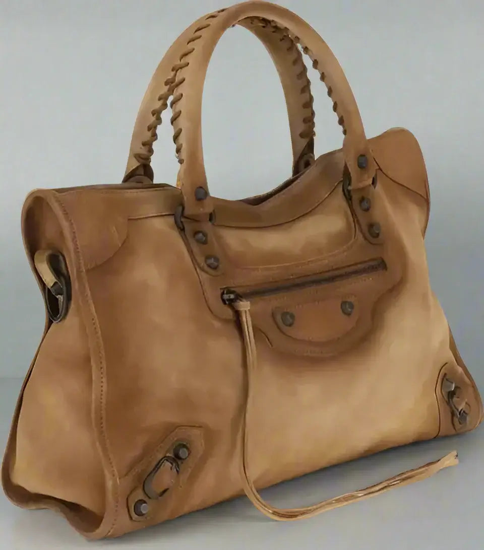 Brown leather handbag with braided handle on a white background