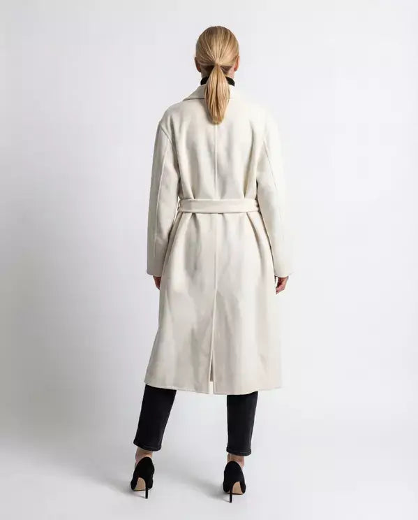 Person wearing a long beige coat on a white background