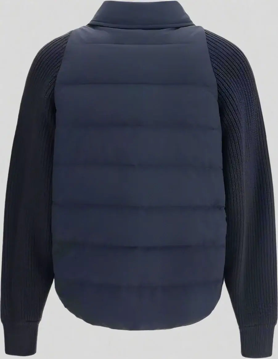 Navy puffer vest over a dark sweater on a white background