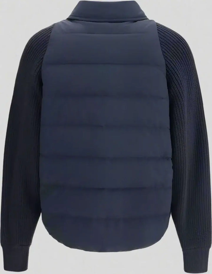 Navy puffer vest over a dark sweater on a white background