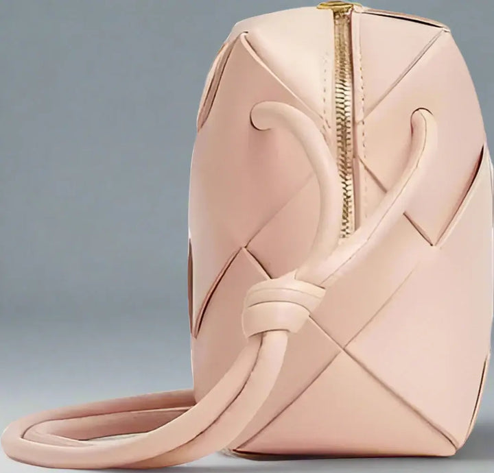 Pink woven handbag with a gold zipper on a white background
