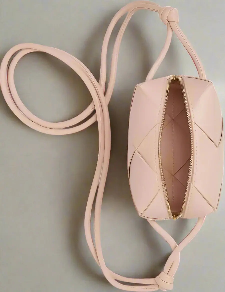 Pink quilted handbag with a strap on a white background