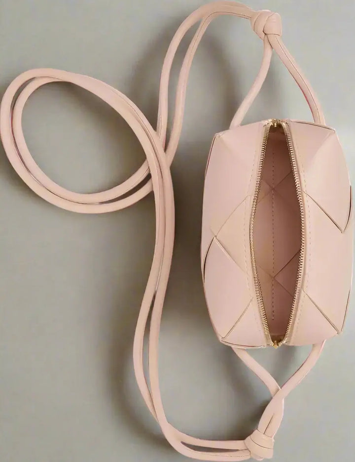 Pink quilted handbag with a strap on a white background