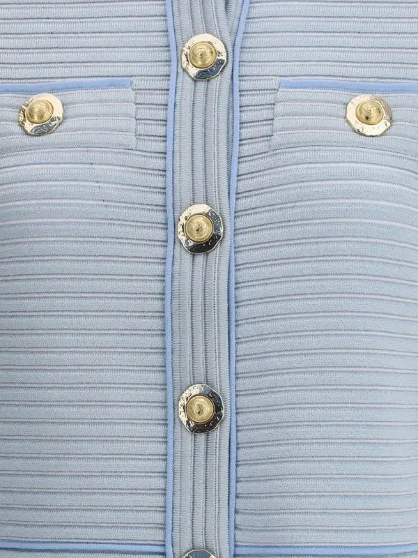 Close-up of a light blue textured fabric with gold buttons.