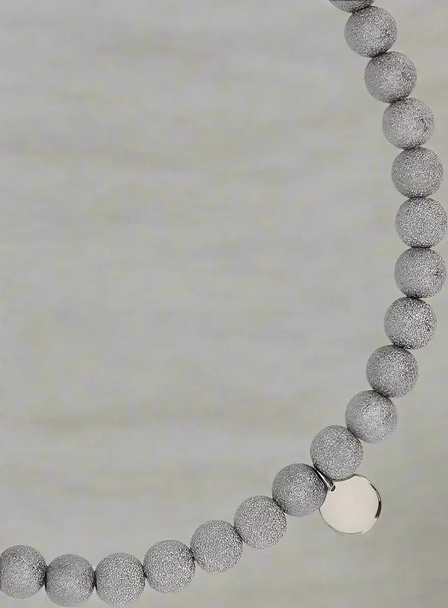 Necklace with gray beaded chain and silver clasp on a white background