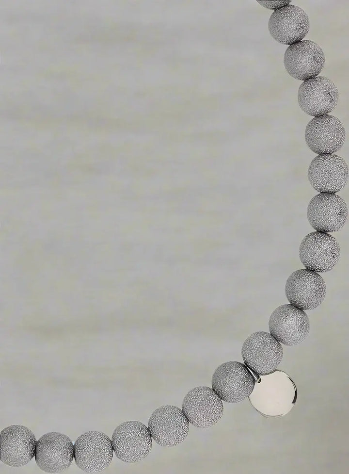 Necklace with gray beaded chain and silver clasp on a white background