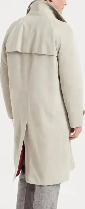 Person wearing a beige trench coat on a white background