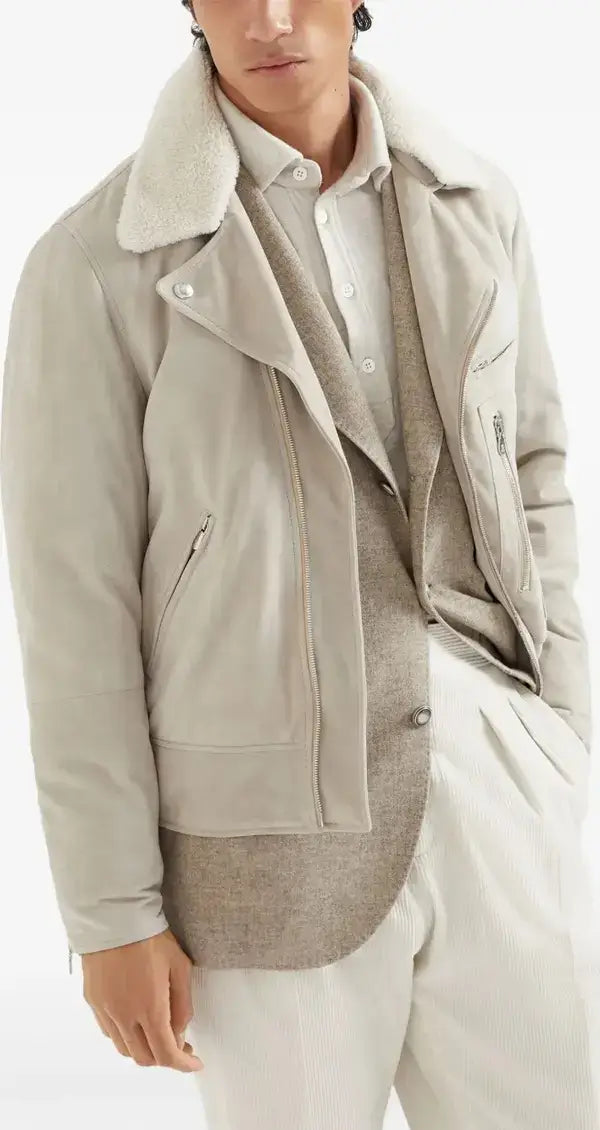 Person wearing a beige jacket over a white shirt and pants on a white background
