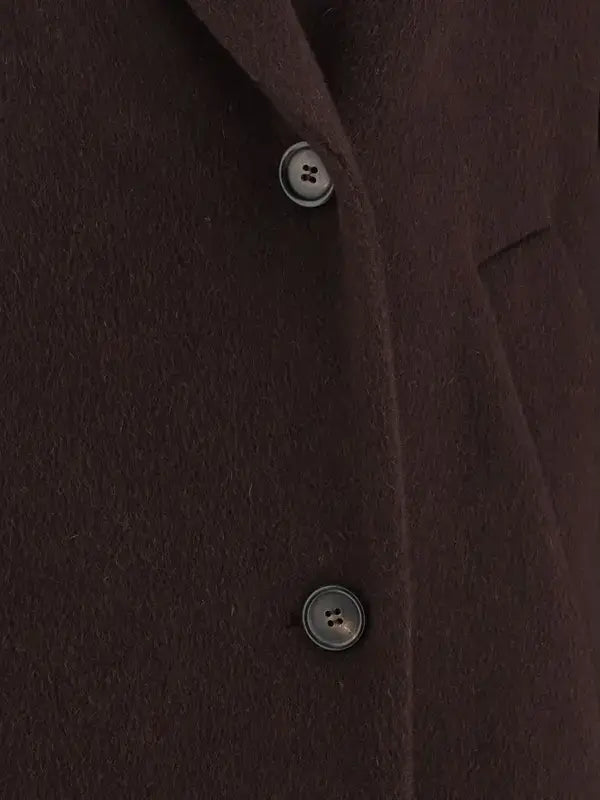 Close-up of a brown coat with buttons on a dark background