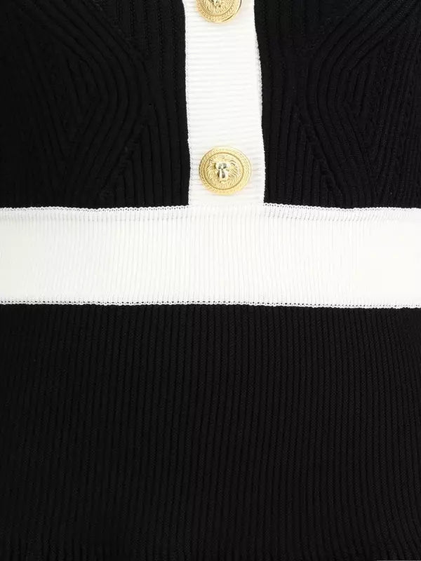 Close-up of a black and white striped garment with gold buttons.