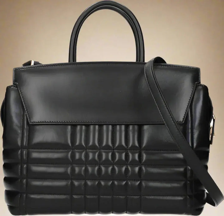 Black quilted handbag with a shoulder strap on a white background