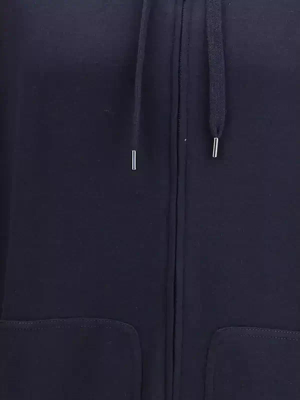 Close-up of a navy blue zip-up hoodie with a focus on the zipper and hood.