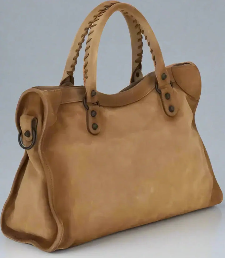 Brown leather handbag with braided handles on a white background
