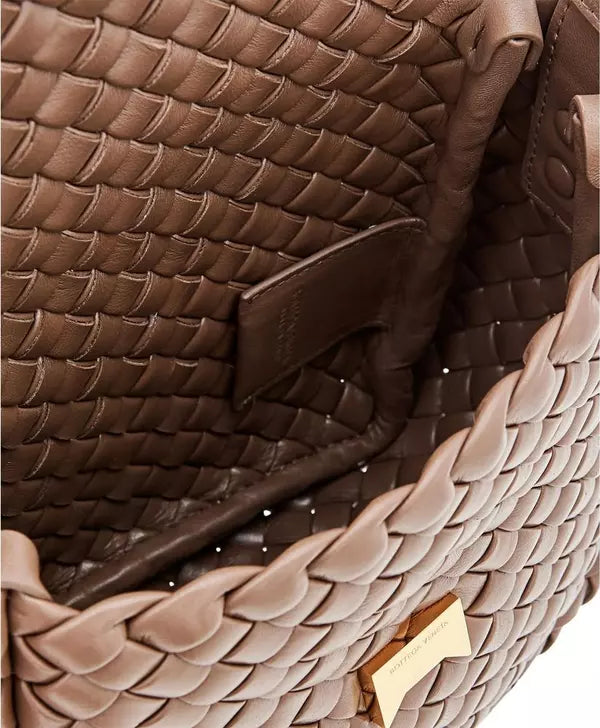 Close-up of a braided brown leather handbag with a gold clasp.