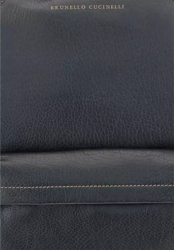 Close-up of dark blue leather with visible stitching, featuring Brunello Cucinelli branding.