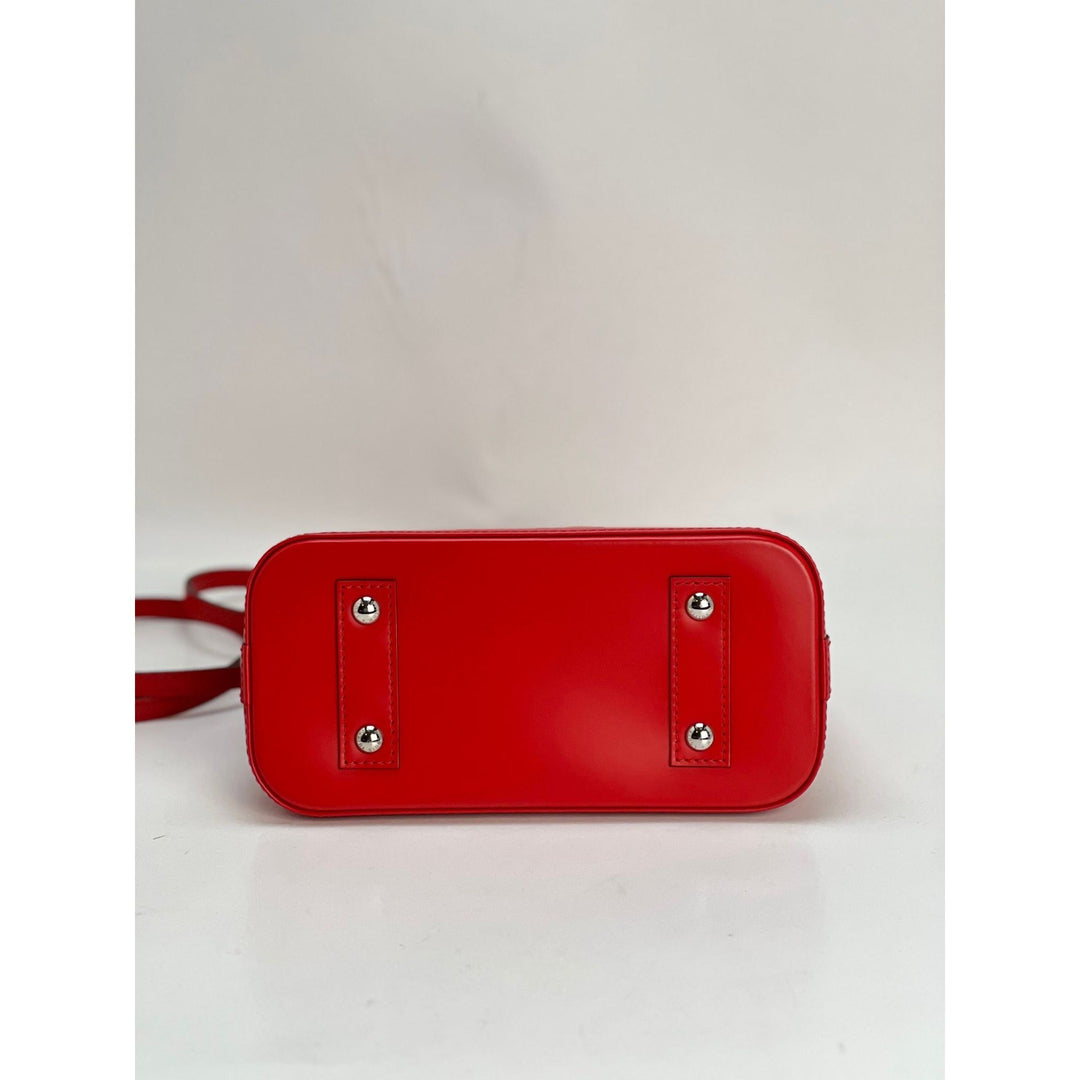 Red handbag with silver studs on a light gray background