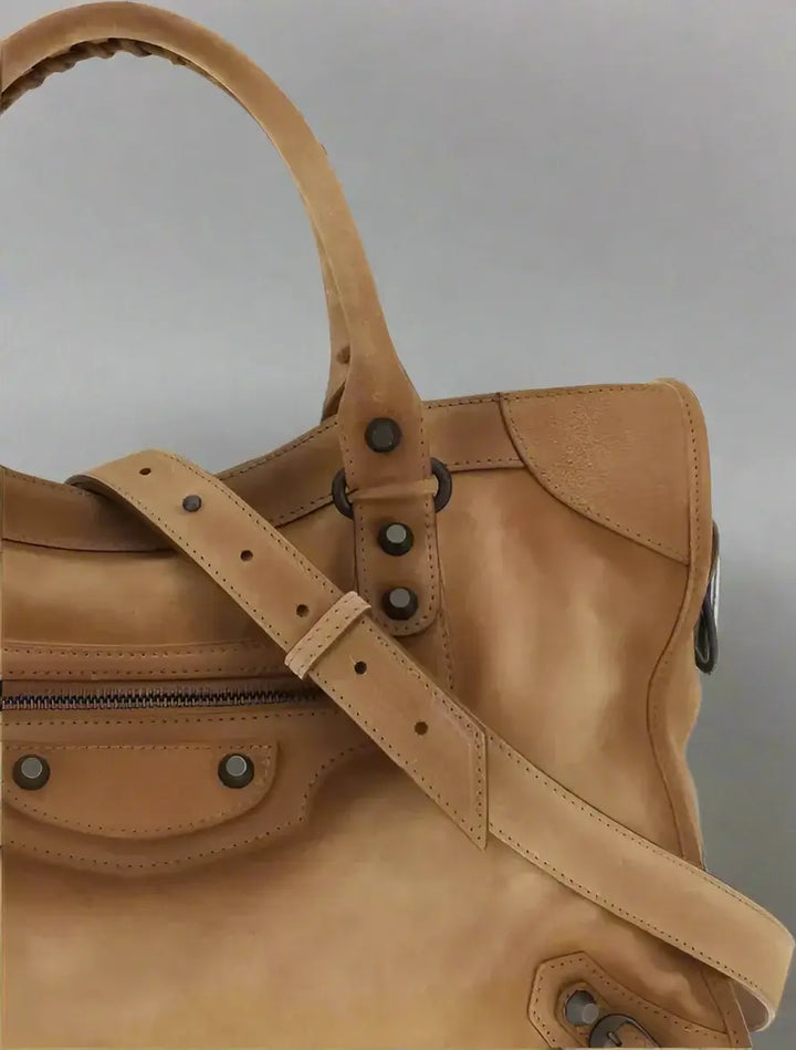 Brown leather handbag with a strap on a white background