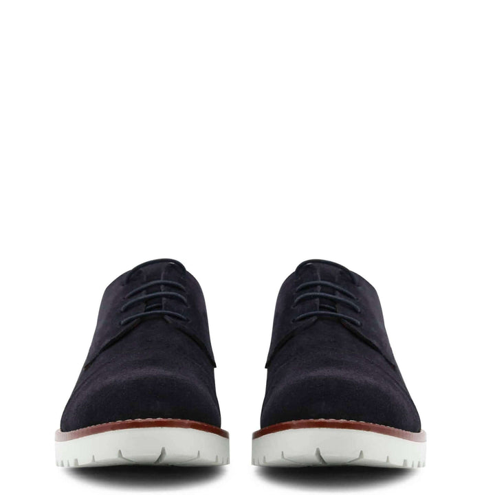 Pair of navy blue shoes with white soles on a white background