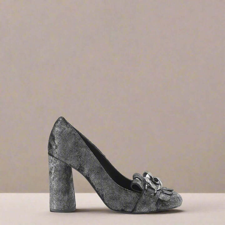 Silver glitter high-heeled shoe with a chain detail on a white background
