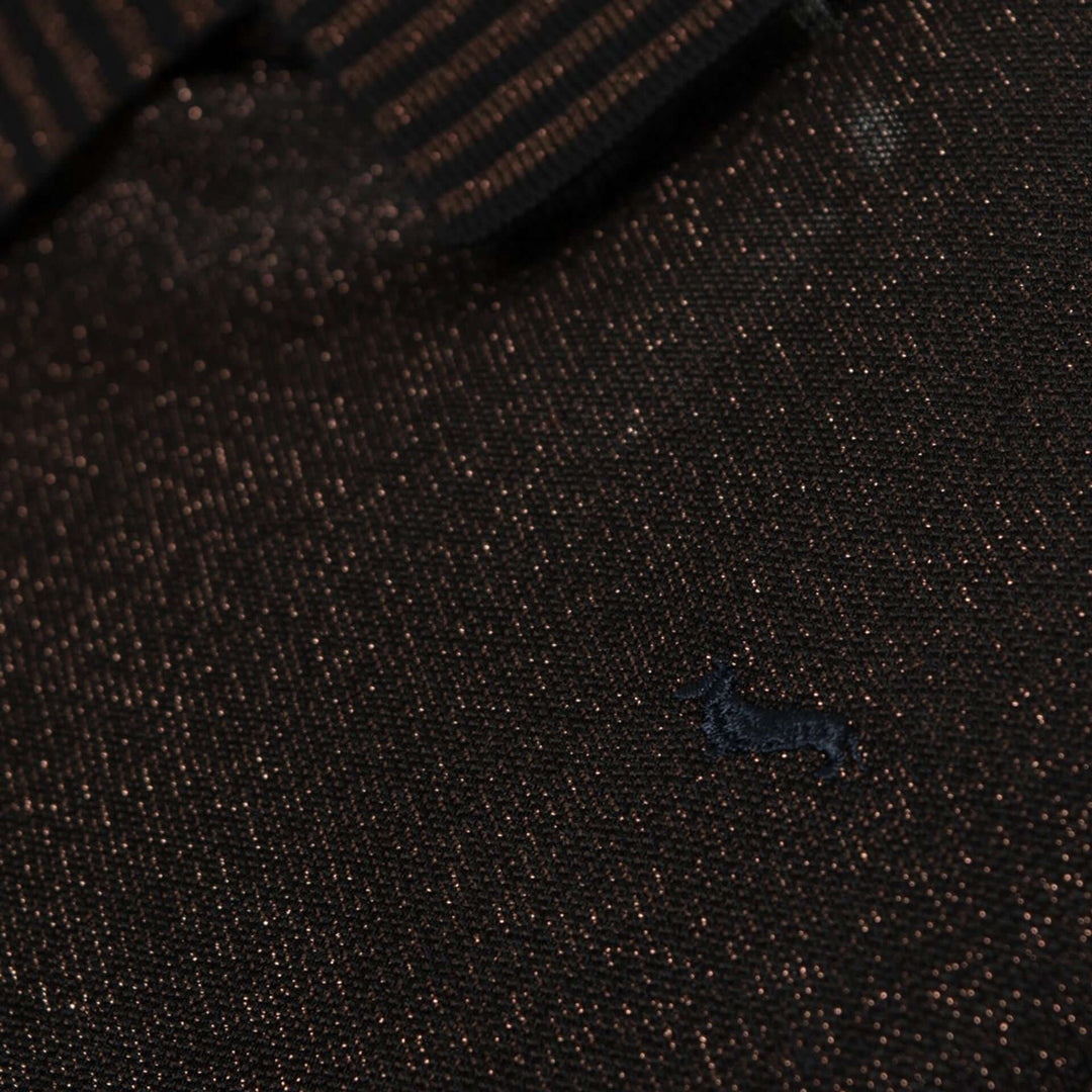 Close-up of a textured dark fabric with a small logo in the corner.
