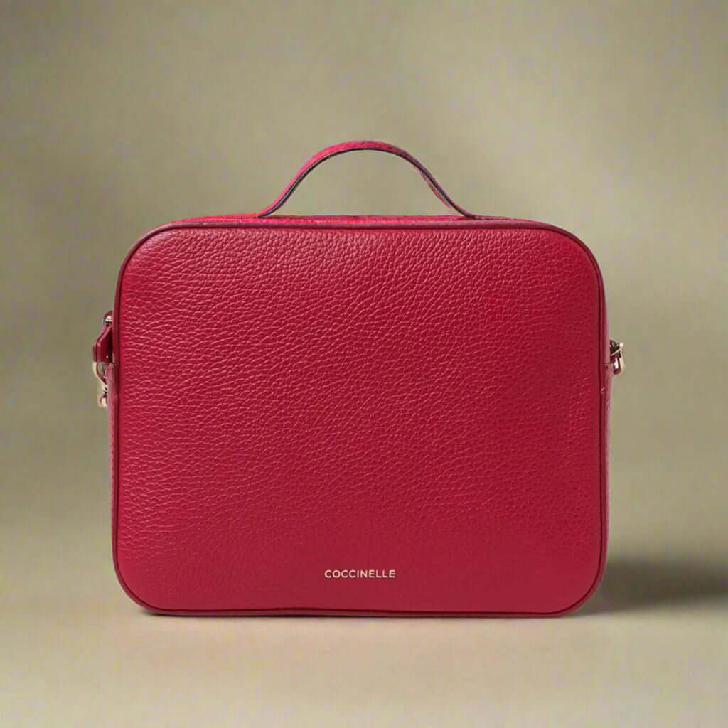 Red leather bag with 'Coccinelle' branding on a white background