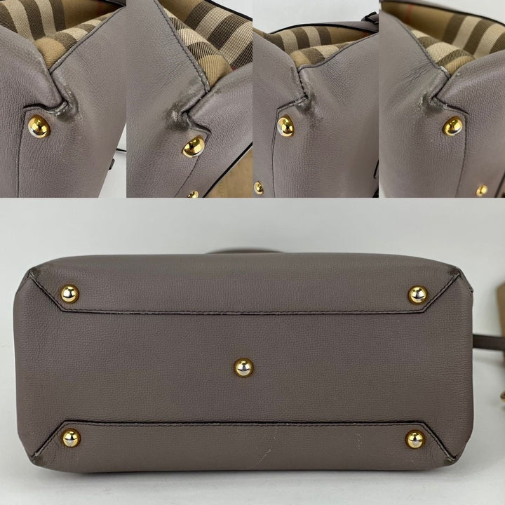 Gray handbag with gold studs on a white background