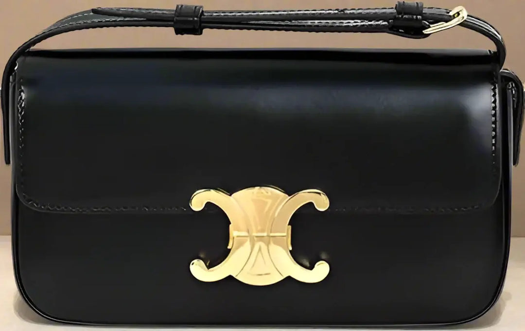 Black handbag with a gold emblem on a black background