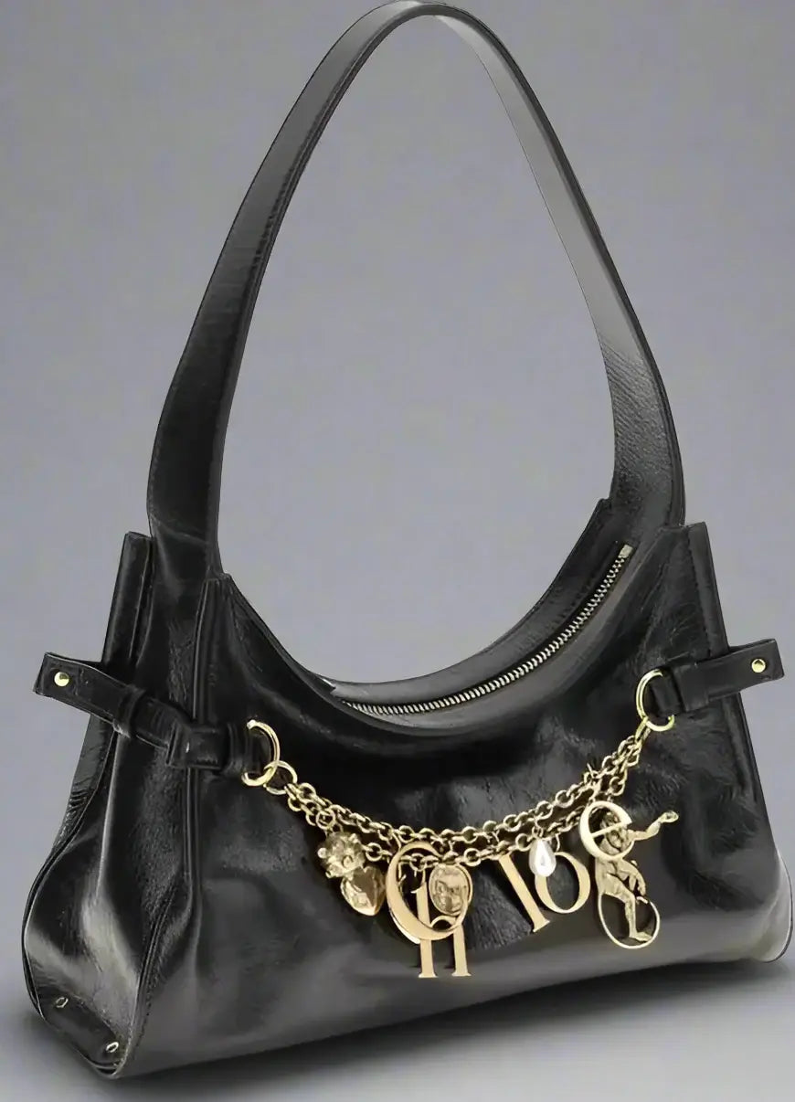 Black handbag with gold charms on a white background