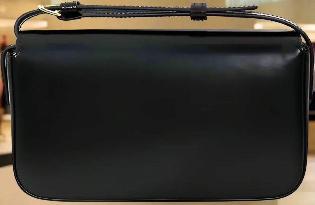Black leather handbag with a strap on a white background