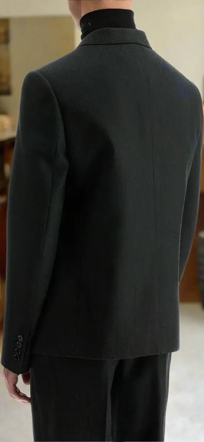 Dark gray suit jacket worn by a person on a white background