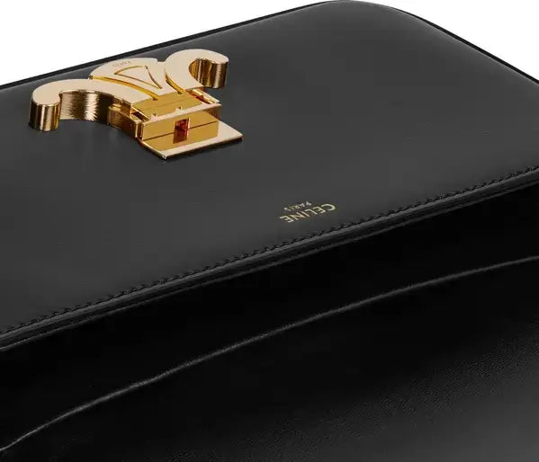 Black handbag with gold logo on a white background