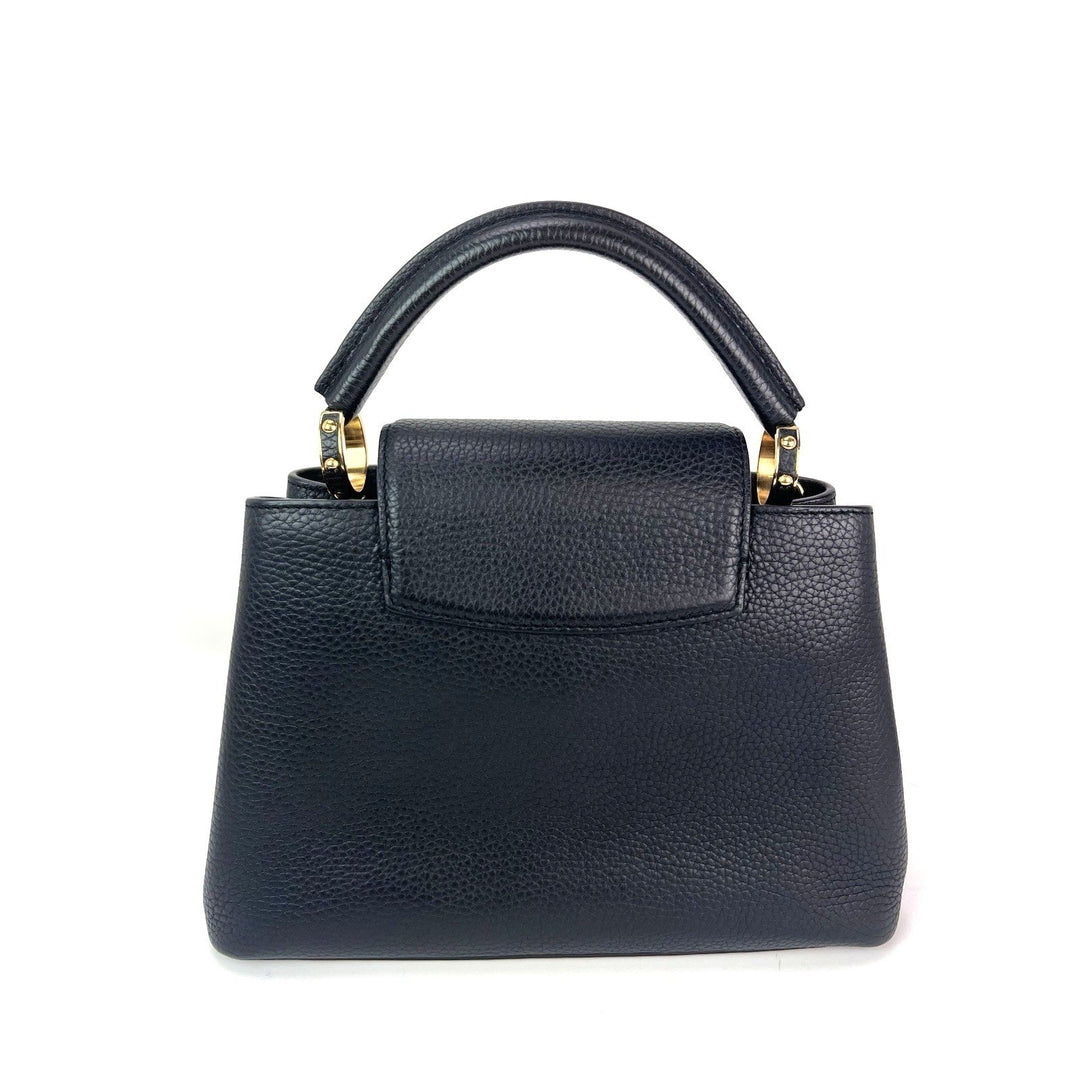 Black handbag with gold accents on a white background