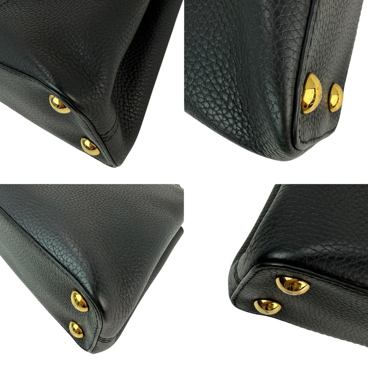 Close-up of a black leather product with gold rivets on a white background