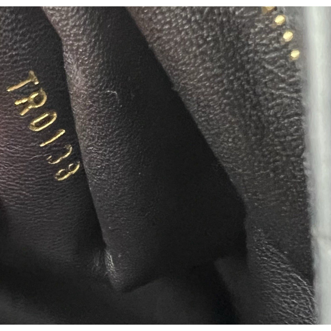 Close-up of black textured fabric with gold 'TR0138' branding.