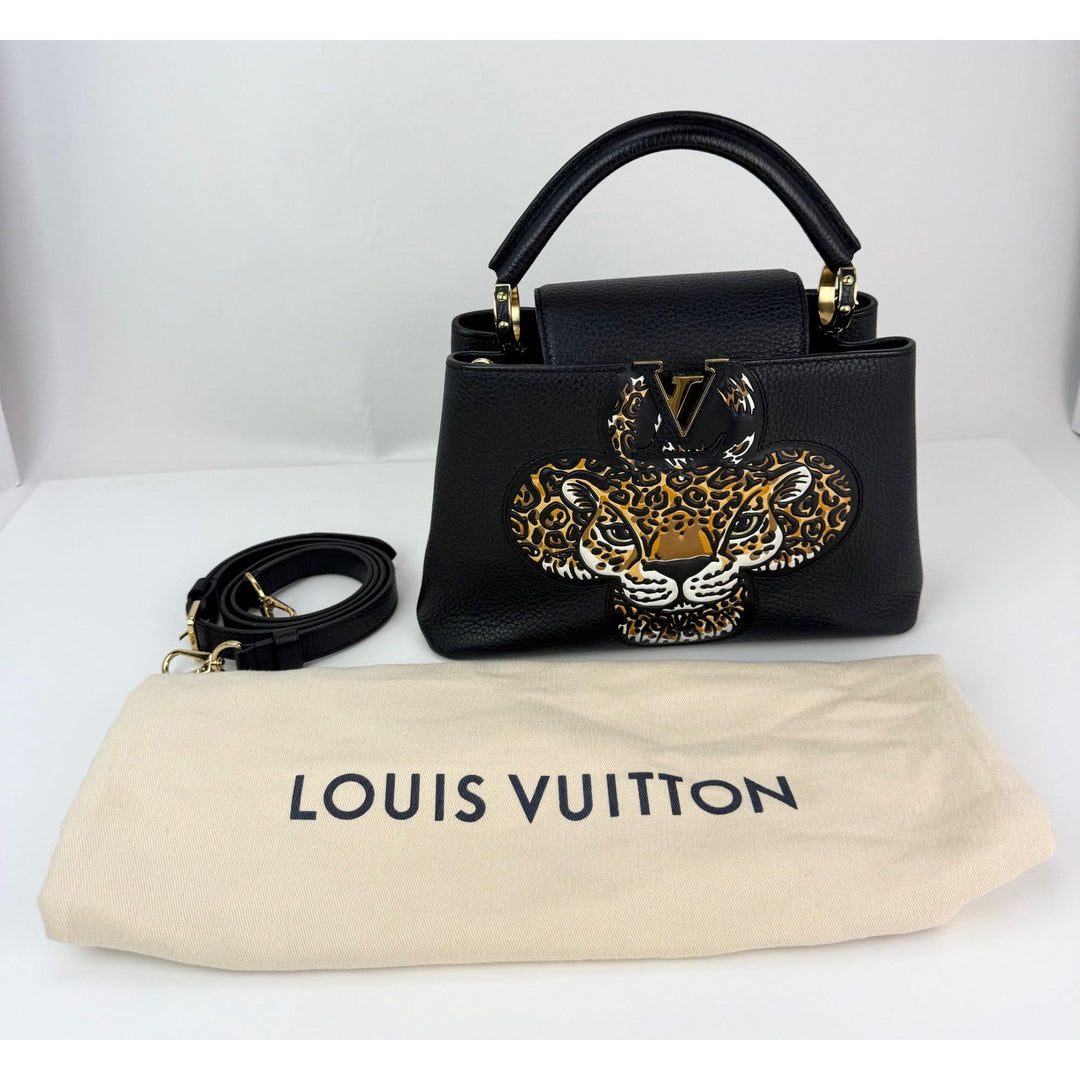 Black handbag with leopard design and matching strap on a white background, featuring Louis Vuitton branding.