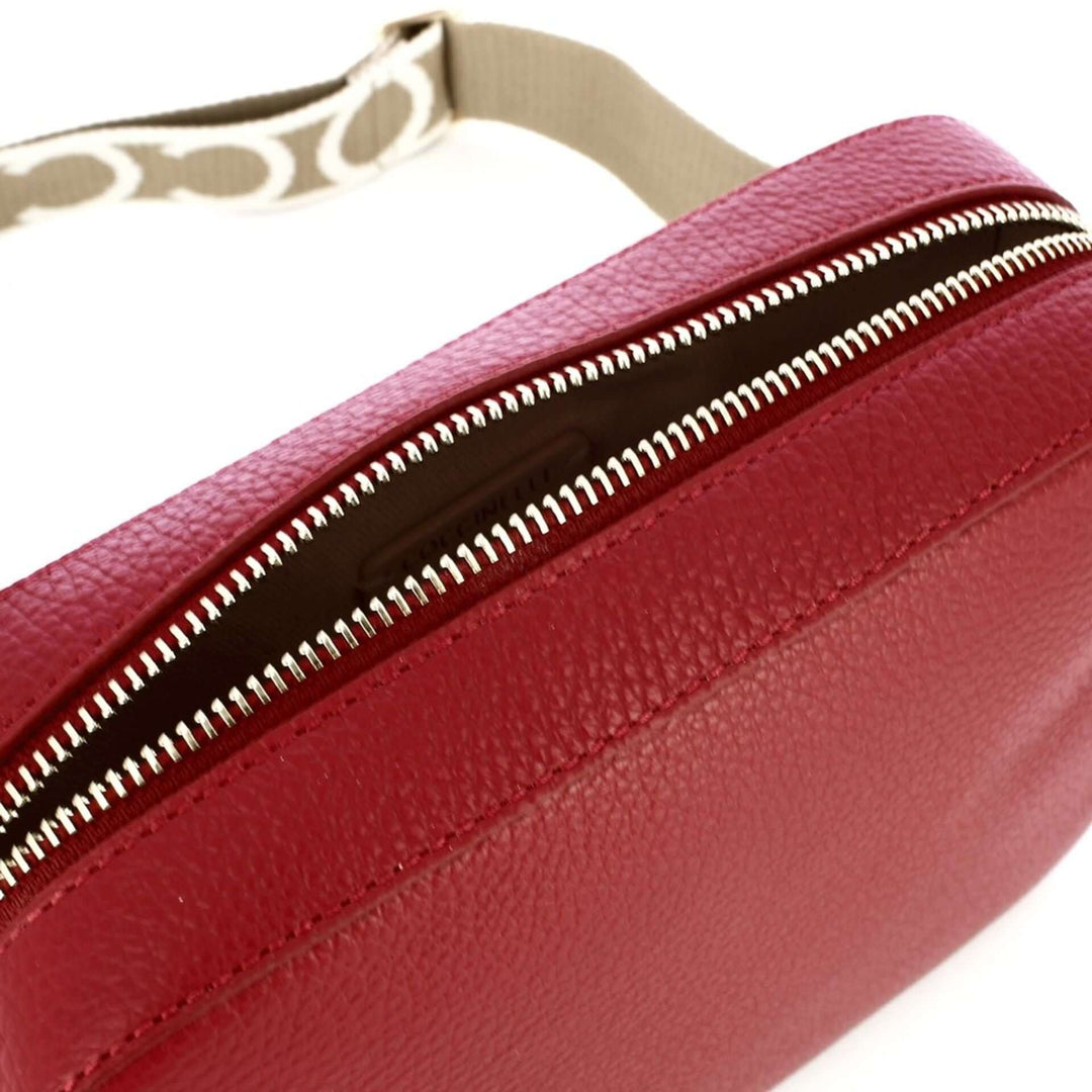 Close-up of a red leather bag with a zipper on a white background