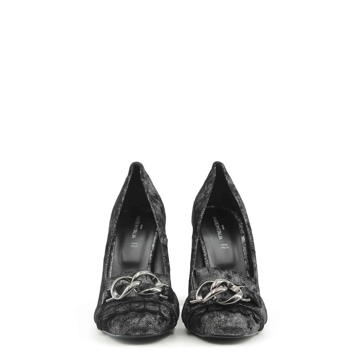 Pair of black glittery high heels with silver bow on a white background