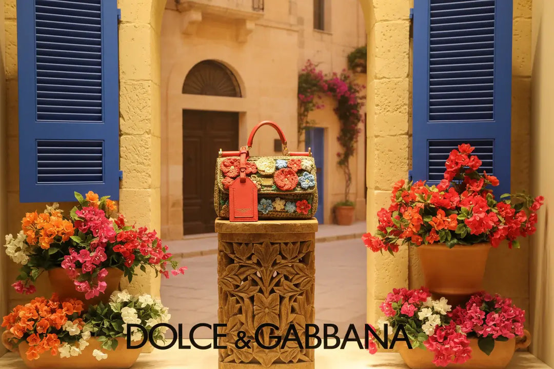 Dolce & Gabbana handbag with floral patterns and a red tag on a white background