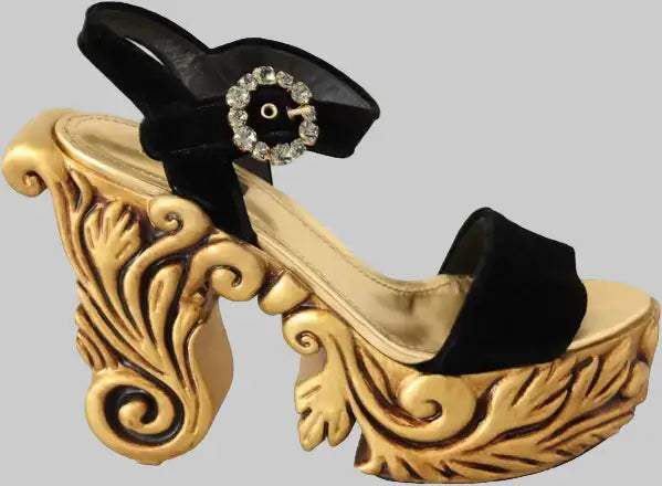 Decorative shoe with gold design and black ribbon on a white background